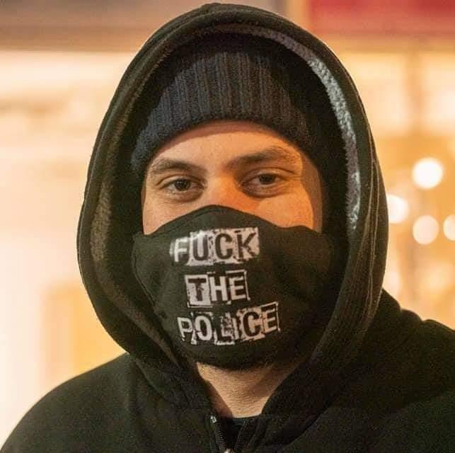 Jeremy Ryan in a black hoodie and a mask reading Fuck the Police.
